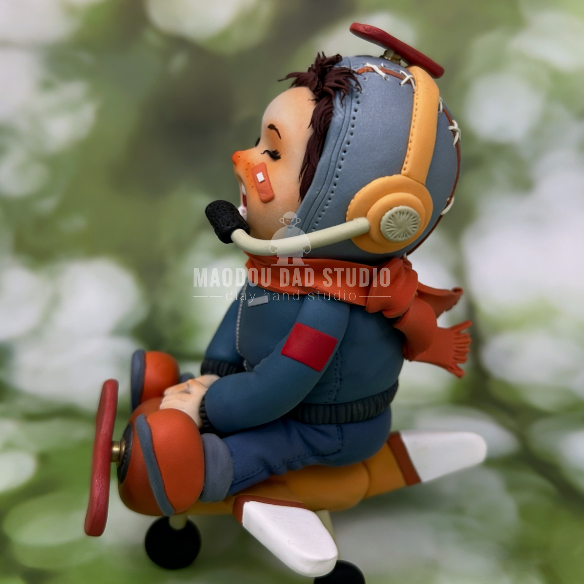 Hand-sculpted pilot clay figurine – side view showing helmet and oversized headphones